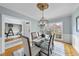 Bright dining room with a glass table and chandelier, complemented by soft blue walls and hardwood floors at 8720 Deerland Grove Dr, Raleigh, NC 27615