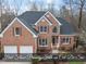 Beautiful two-story brick home featuring a two-car garage, manicured landscaping, and a classic design at 8720 Deerland Grove Dr, Raleigh, NC 27615