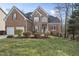 Charming brick home with a well-manicured lawn, featuring an attached two-car garage and classic architectural details at 8720 Deerland Grove Dr, Raleigh, NC 27615