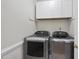 Laundry room featuring front load washer and dryer, white cabinets, and a neutral color scheme at 8720 Deerland Grove Dr, Raleigh, NC 27615