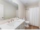 Bright bathroom featuring a modern vanity with white countertop, framed mirror, and shower with curtain at 9249 Miranda Dr, Raleigh, NC 27617