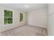 Bright bedroom features neutral walls, soft carpet, and two windows with treed outdoor view at 9249 Miranda Dr, Raleigh, NC 27617