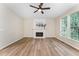 Cozy living room with wood floors, a fireplace, a ceiling fan, and a large picture window at 9249 Miranda Dr, Raleigh, NC 27617