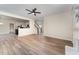 Open-concept living room with hardwood floors, ceiling fan, and view into the kitchen at 9249 Miranda Dr, Raleigh, NC 27617