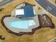 Aerial view of a community pool with surrounding amenities, including a playground and lounging areas at 1016 Channel Drop Lp, Zebulon, NC 27597