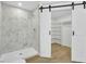 Contemporary bath displaying marble tile shower, sliding barn doors and a walk-in closet at 1041 Limerick Ln, Durham, NC 27713