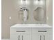 Bathroom features a dual sink vanity, quartz countertop, dark hardware and round mirrors at 1041 Limerick Ln, Durham, NC 27713