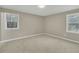 Bedroom featuring neutral-colored carpet, fresh paint, and two windows, inviting ample sunlight at 1041 Limerick Ln, Durham, NC 27713