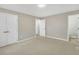Bedroom featuring neutral-colored carpet, fresh paint, and two closets, inviting ample sunlight at 1041 Limerick Ln, Durham, NC 27713