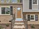 Front entrance featuring brick stairs, a wood door, and gray and black siding at 1041 Limerick Ln, Durham, NC 27713