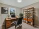 Functional home office featuring a sleek wooden desk, comfortable black leather chair, and a wooden bookshelf filled with books at 1041 Limerick Ln, Durham, NC 27713