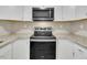 Kitchen includes stainless steel range and microwave with granite counter tops and white cabinets at 1041 Limerick Ln, Durham, NC 27713
