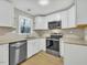 Well-lit kitchen with stainless steel appliances, modern sink, and new cabinets at 1041 Limerick Ln, Durham, NC 27713