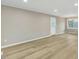 Expansive living room with wood-look floors, neutral paint, a contemporary light fixture, and a door to the outside at 1041 Limerick Ln, Durham, NC 27713