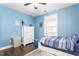 Bright bedroom featuring blue walls, hardwood floors and a cozy bed at 1103 River Birch Way Way, Mebane, NC 27302