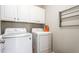 A bright laundry room with white washer and dryer, white cabinets, and a drying rack at 1103 River Birch Way Way, Mebane, NC 27302