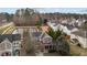 Aerial view of the home with a pond, mature trees, and a surrounding neighborhood at 1104 Pebblestone Dr, Durham, NC 27703