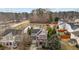 Aerial view of the property with a pond, a tree-lined street and surrounding homes at 1104 Pebblestone Dr, Durham, NC 27703
