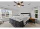 Spacious main bedroom featuring a tray ceiling, a ceiling fan, and large windows offering scenic views at 1104 Pebblestone Dr, Durham, NC 27703
