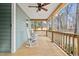 Relaxing covered porch features rocking chairs and a ceiling fan overlooking the backyard at 115 N Oakland Dr, Mebane, NC 27302