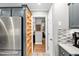 Kitchen area with open shelving and stainless steel refrigerator at 115 N Oakland Dr, Mebane, NC 27302