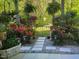 Landscaped backyard with stone pathway, decorative lighting, mature ferns and flowering bushes at 11843 Canemount St, Raleigh, NC 27614