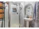 This bathroom features a standing shower with see through glass doors and a pedestal sink with an oval mirror at 11843 Canemount St, Raleigh, NC 27614