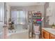 Relax in this bathroom with an elevated soaking tub, vanity, modern fixtures, and bright window at 11843 Canemount St, Raleigh, NC 27614
