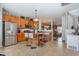 Spacious kitchen with wooden cabinetry, a stainless steel refrigerator, and a center island with barstools at 11843 Canemount St, Raleigh, NC 27614