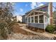 Back of the house features a sunroom, stone garden and mature landscaping at 1212 Eastham Dr, Apex, NC 27502