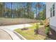 Backyard with concrete patio, retaining wall, young trees, and manicured landscaping at 122 Weavers Grove Dr, Chapel Hill, NC 27514