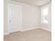 A clean, carpeted bedroom featuring a window with natural light and a white door at 122 Weavers Grove Dr, Chapel Hill, NC 27514