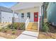 Close up of the home's front porch featuring a vibrant red door and wood stairs at 122 Weavers Grove Dr, Chapel Hill, NC 27514
