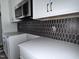Close-up of kitchen backsplash, countertops and cabinets; modern tile design and neutral color palette at 122 Weavers Grove Dr, Chapel Hill, NC 27514