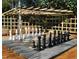 Outdoor chess board with full-size pieces under a wooden trellis at 122 Weavers Grove Dr, Chapel Hill, NC 27514