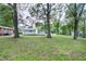 Lush backyard with mature trees and multiple outbuildings providing ample storage space at 1418 Kirkwood Drive Dr, Durham, NC 27705