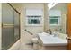 Bathroom with a shower, a sink, floral wallpaper, and a window providing natural light at 1418 Kirkwood Drive Dr, Durham, NC 27705