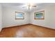 Bedroom featuring hardwood floors, two windows, and a ceiling fan at 1418 Kirkwood Drive Dr, Durham, NC 27705