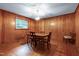Traditional dining room with wood-paneled walls, hardwood floors, and a classic chandelier above the wood table at 1418 Kirkwood Drive Dr, Durham, NC 27705