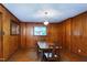 Traditional dining room with wood-paneled walls, hardwood floors, and a classic chandelier above the wood table at 1418 Kirkwood Drive Dr, Durham, NC 27705