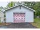 A detached garage painted white with a red square paneled garage door at 1418 Kirkwood Drive Dr, Durham, NC 27705