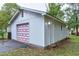 Detached garage with a unique square paneled red and white garage door at 1418 Kirkwood Drive Dr, Durham, NC 27705