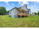 Beautiful backyard with a wooden deck, gray siding, and a well-maintained lawn at 1604 Palmer Dr, Graham, NC 27253