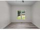 Minimalist bedroom with stylish gray flooring, bright window, and natural light, creating a simple and cozy atmosphere at 1604 Palmer Dr, Graham, NC 27253