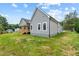 Exterior view of the house from backyard featuring gray siding, a wooden deck, and green grass at 1604 Palmer Dr, Graham, NC 27253