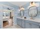 Bathroom with double vanity, blue paneling, and access to the main bedroom at 1636 Sweetwater Ln, Raleigh, NC 27610