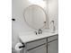 Modern bathroom with round mirror, grey vanity, and contemporary fixtures at 1636 Sweetwater Ln, Raleigh, NC 27610