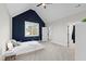 Bedroom with vaulted ceiling, a decorative blue accent wall, a window, and carpeted flooring at 1636 Sweetwater Ln, Raleigh, NC 27610