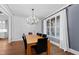 Elegant dining room featuring stylish paneling, a modern light fixture, and views of the manicured exterior at 1636 Sweetwater Ln, Raleigh, NC 27610