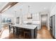 Bright and airy kitchen with a gray island, wood bar stools, and stainless appliances at 1636 Sweetwater Ln, Raleigh, NC 27610